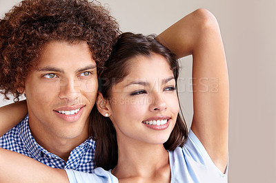 Buy stock photo Studio shot of a romantic young couple holding each other and looking away