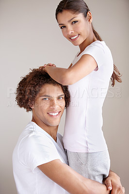 Buy stock photo Studio portrait of a beautiful young couple holding each other in a playful way
