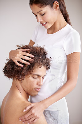 Buy stock photo A young ethnic couple holding each other gently with the man's head resting on his spouse's stomach