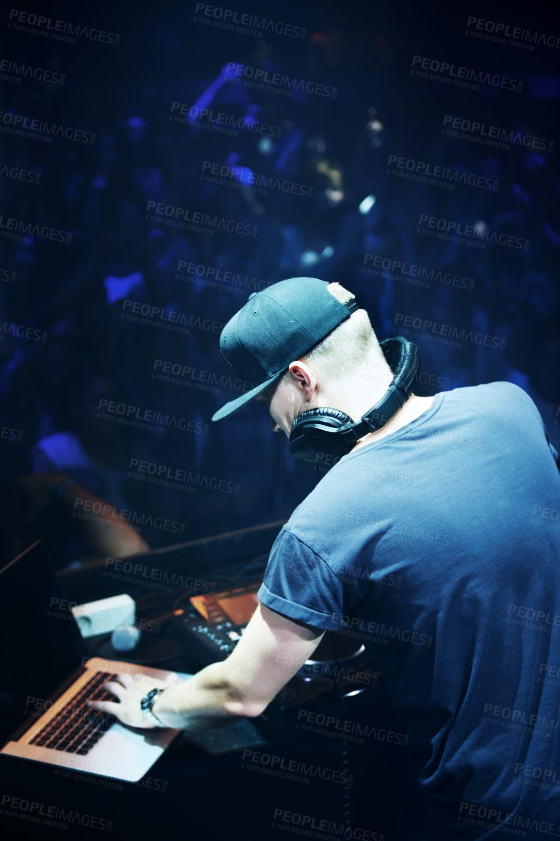 Buy stock photo Concert, DJ and man with mixing music by stage and laptop in color spotlight with large crowd. Young person, creative and talented musician in band for sound and performance at event on night club