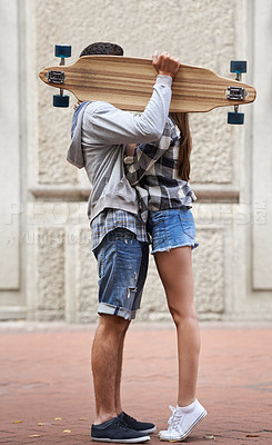 Buy stock photo Couple, hiding with skateboard and outdoor in city, hug and excited to learn together and romantic relationship. Cape town, touch and hobby with boyfriend and girlfriend in street, love and dating