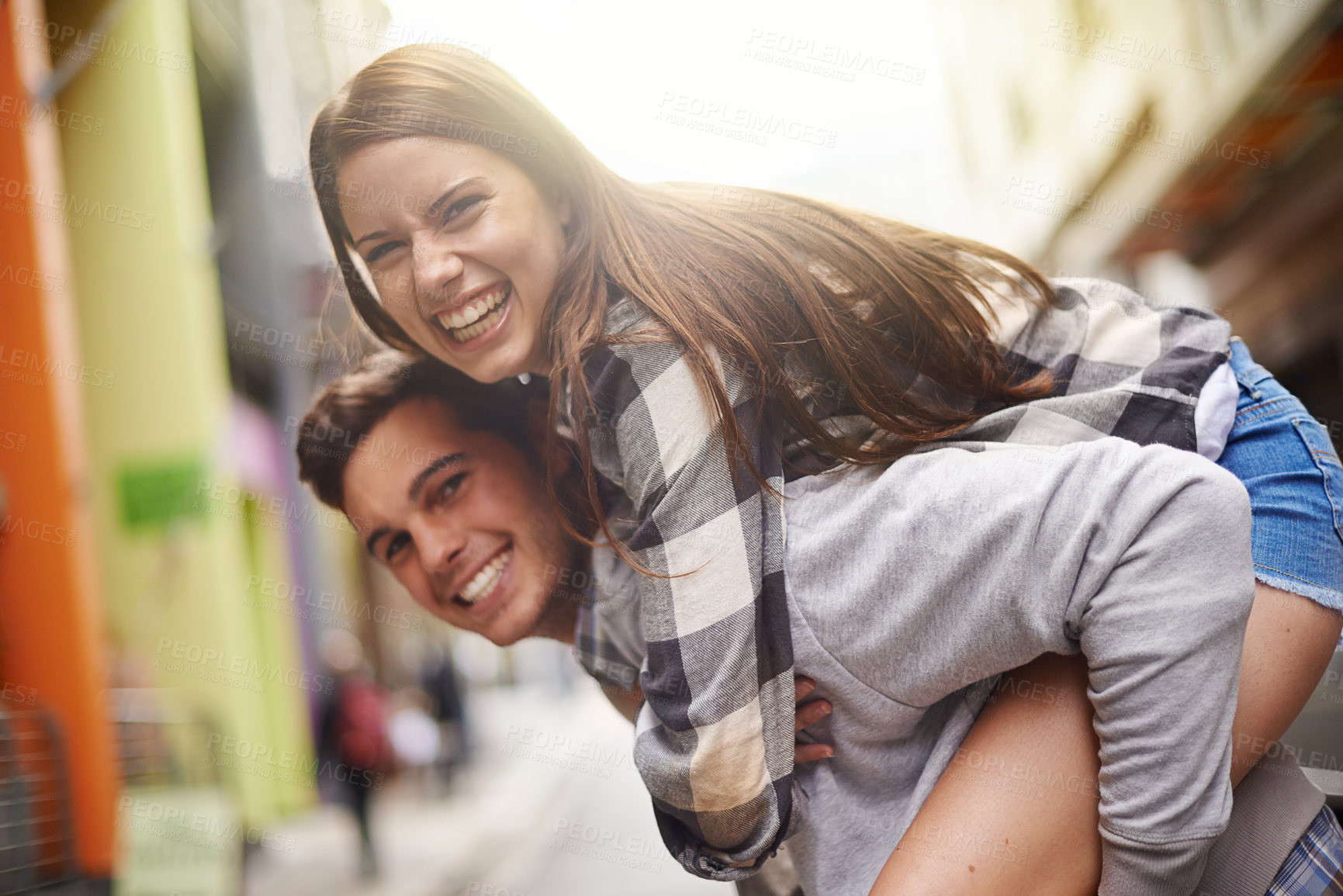 Buy stock photo Happiness, hug and portrait of couple piggyback ride for fun urban adventure, bonding and city journey. Wellness, embrace and young man, woman or people smile for relationship, goofy game or break