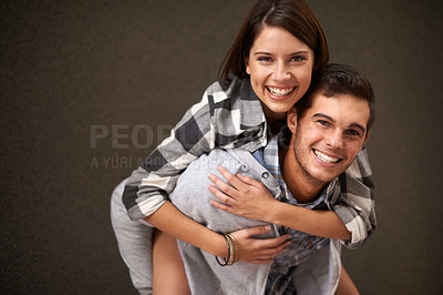 Buy stock photo Studio, hug and portrait of happy couple, piggyback ride and having playful fun together on brown background. Wellness, embrace and young silly man, woman or people smile for goofy game