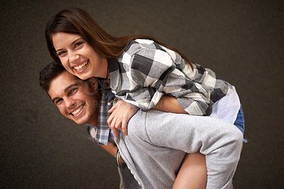 Buy stock photo Smile, hug and portrait of couple piggyback ride, bond and having playful fun isolated on grey background. Support, embrace and young silly man, woman or people happy for funny game with partner