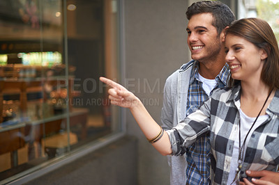 Buy stock photo Bakery, pointing and couple with love, hug and conversation with romance, customer and cheerful. Outdoor, happy man and woman with embrace, joyful or shopping with cakes, discount deal and discussion