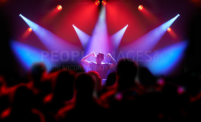 Buy stock photo REarview shot of a large group of music fans looking at a musician on stage