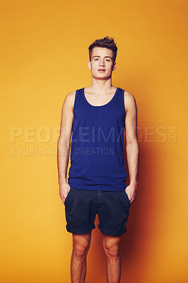 Buy stock photo Fashion, portrait and man in studio with trendy, cool or summer clothes on orange background. Style, attitude or serious male model with confidence, personality or casual, streetwear or outfit choice