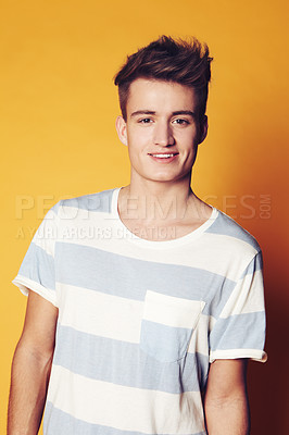 Buy stock photo Portrait, fashion and man with style, smile and confident guy on an orange studio background. Face, person and model with student, casual outfit and stylish clothes with gen z, t shirt and aesthetic