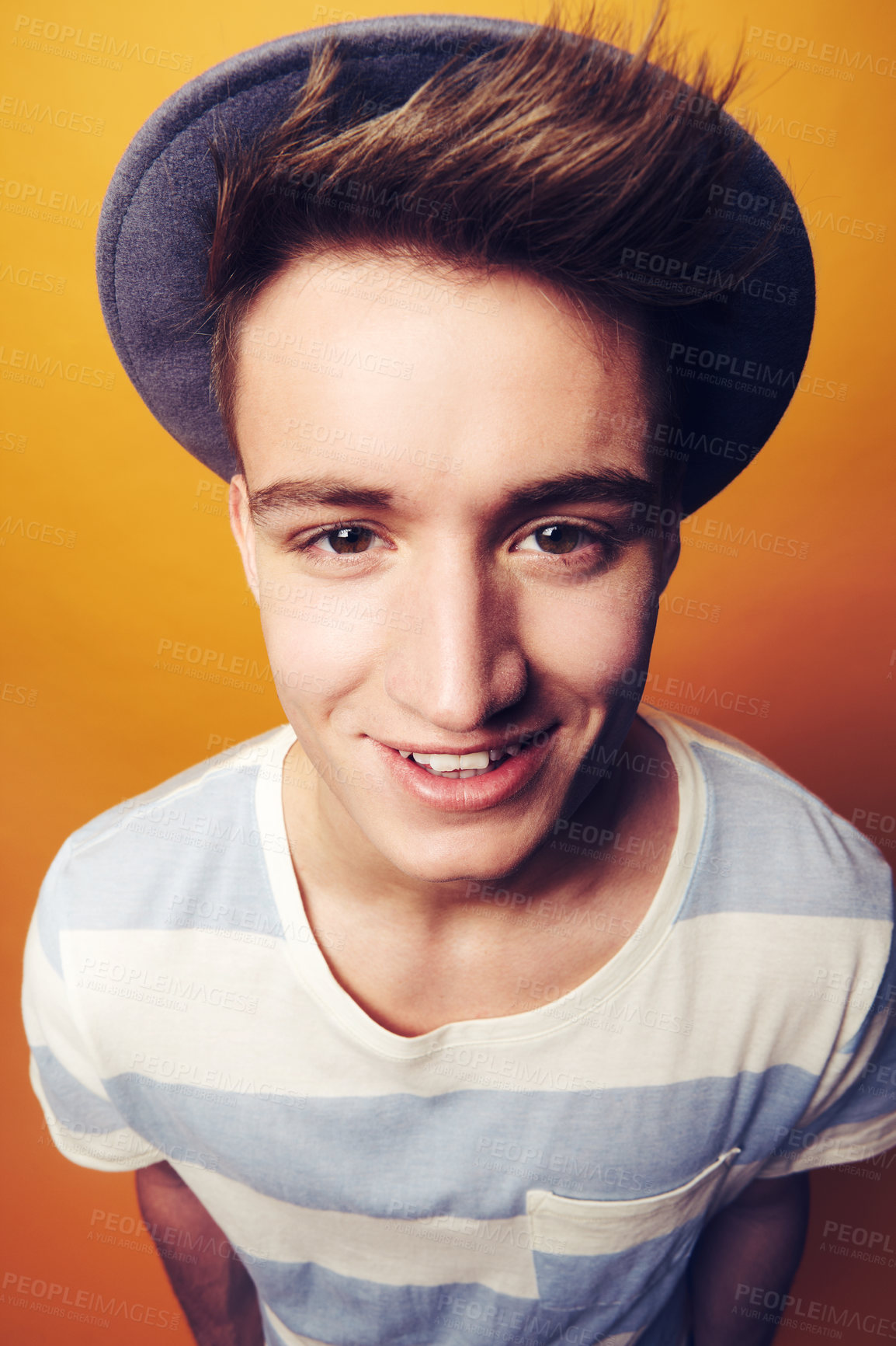Buy stock photo Portrait, hat and man with fashion, smile and confident guy on an orange studio background. Face, person and model with accessory, student and aesthetic with casual outfit, trendy and stylish clothes