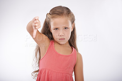 Buy stock photo Thumbs down, child or portrait of girl in studio for bad news, emoji sign and vote no for feedback on white background. Unhappy kid, negative review or failure of decision, wrong results or rejection