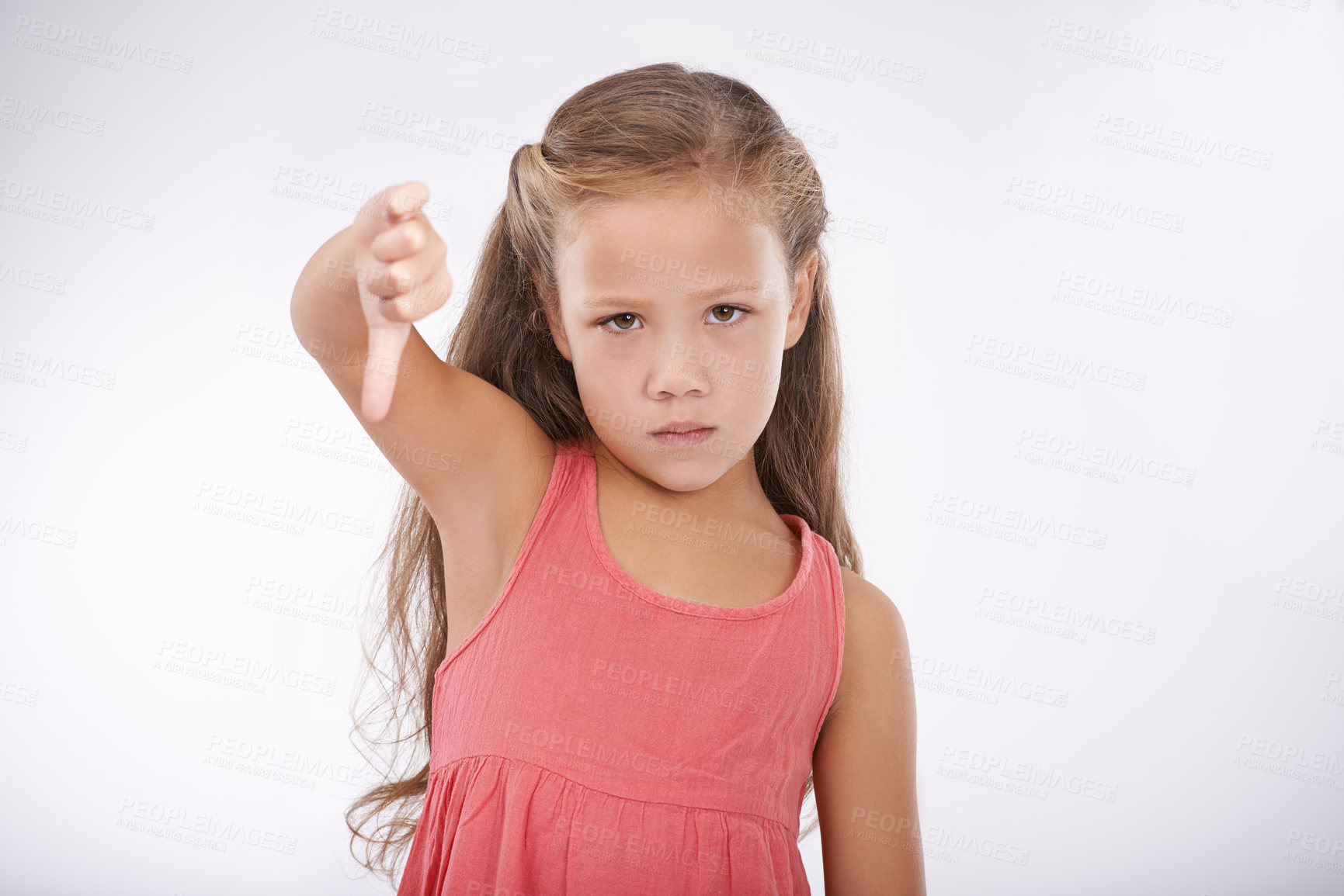 Buy stock photo Thumbs down, child or portrait of girl in studio for bad news, emoji sign and vote no for feedback on white background. Unhappy kid, negative review or failure of decision, wrong results or rejection