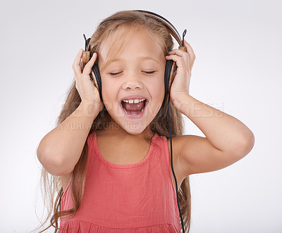 Buy stock photo Girl kid, music and singing with headphones in studio for audio, subscription and streaming multimedia on white background. Happy child, shouting and listening to podcast, hearing sound and radio 