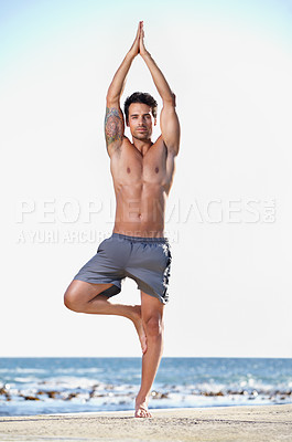 Buy stock photo Full length shot of a young man exercising at the beach