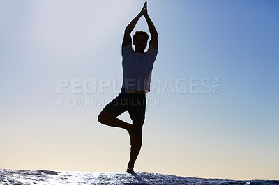Buy stock photo Man, silhouette and yoga in meditation on beach for spiritual wellness, inner peace or mental wellbeing in nature. Calm male yogi in tree pose for balance, healthy body or mindfulness by the ocean