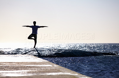 Buy stock photo Man, silhouette and yoga in meditation on beach rock for spiritual wellness, inner peace or mental wellbeing in nature. Male yogi in tree pose for balance, healthy body or mindfulness on the ocean