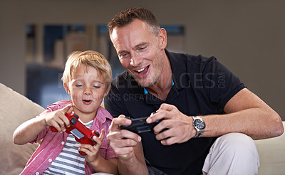 Buy stock photo A father and his son playing video games