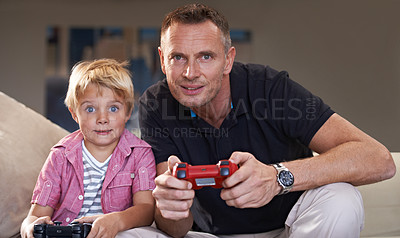 Buy stock photo Family, father and serious son gaming on sofa in living room of home together for love, bonding or competition. Video game, controller for next level and gamer dad with boy child in apartment