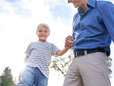 Buy stock photo Father, son and happy in nature with holding hands for bonding, trust and relationship outdoor with blue sky. Family, man or parent and boy child in park with smile, portrait and relax in summer
