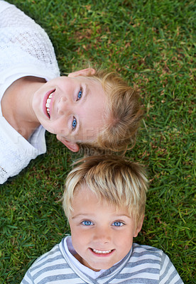 Buy stock photo Smile, portrait of girl and boy on grass together for bonding, outdoor fun and kids from above. Happiness, lawn and face of children in backyard on weekend for playful development, growth and care.