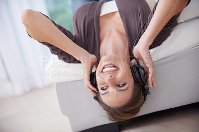 Buy stock photo Happy woman, upside down on couch and headphones for music, audio streaming and wellness with fun at home. Podcast, radio playlist and subscription online, relax in living room with technology