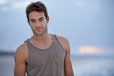 Buy stock photo Portrait of a handsome young man one the beach in the early morning