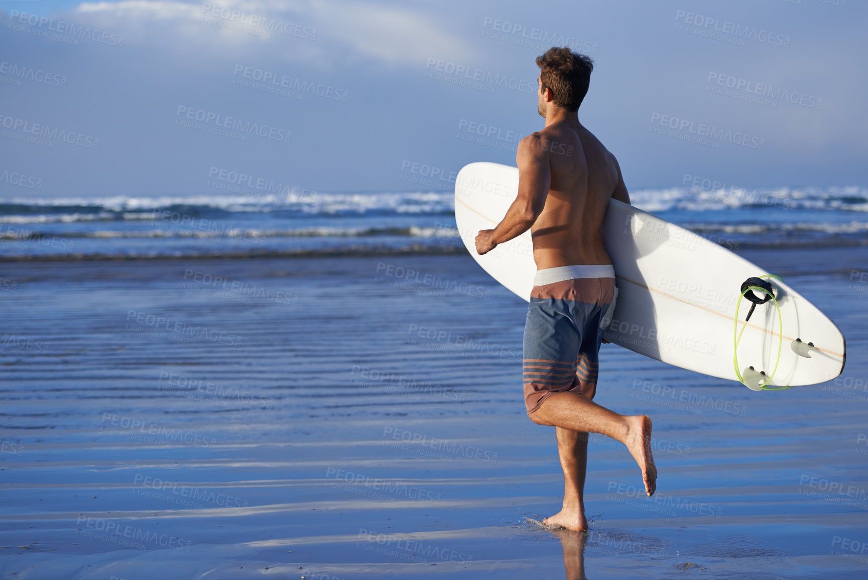 Buy stock photo A handsome young surfer at the beach craving a good wave