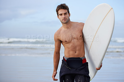 Buy stock photo A handsome young surfer at the beach craving a good wave