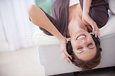 Buy stock photo Woman, smile while upside down on sofa and headphones for music, audio streaming and stress relief for fun at home. Podcast, listen to radio and subscription online, relax in living room with tech