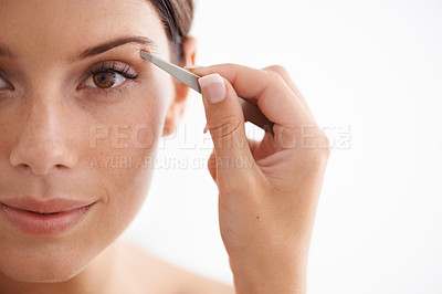 Buy stock photo Portrait of an attractive young woman plucking her eyebrows
