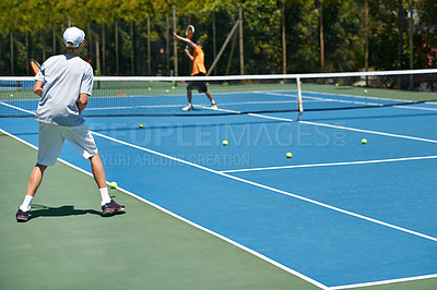 Buy stock photo Shot of a young boy playing tennis on a sunny day