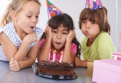 Buy stock photo Friends, children and birthday cake, blowing candles at party with people for celebration, youth and dessert. Special day, together in festive mood and kids smile for social event with chocolate