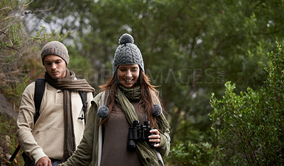 Buy stock photo A young couple with a pair of binoculars outdoors