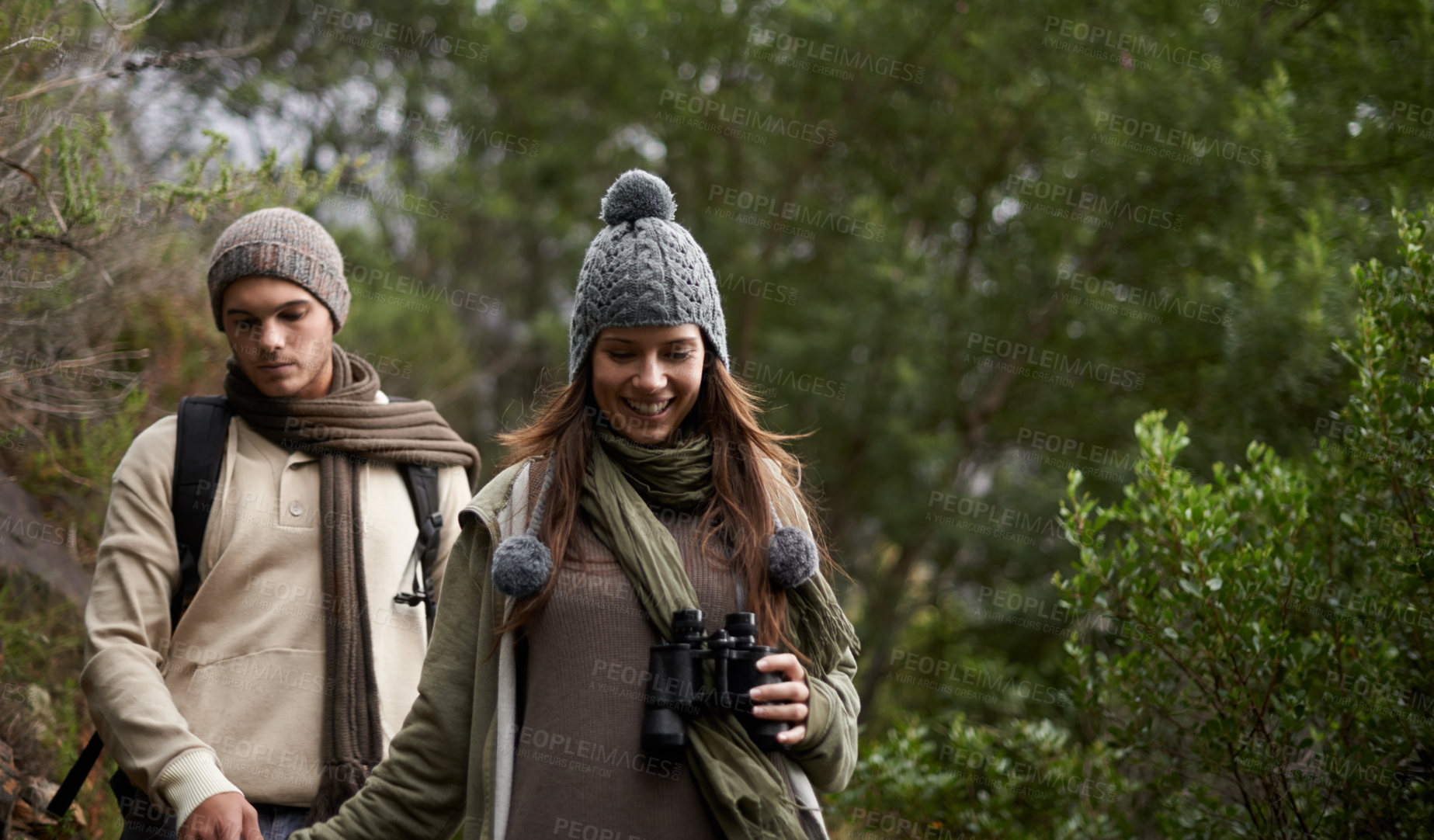 Buy stock photo A young couple with a pair of binoculars outdoors