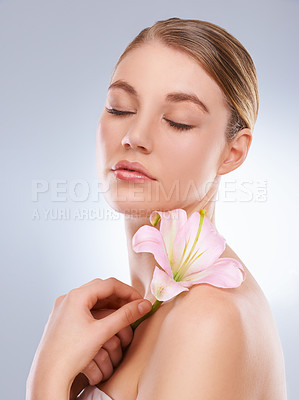 Buy stock photo Eyes closed, beauty and woman with skincare, flowers and wellness on a white studio background. Person, model or girl with natural cosmetics or healthy skin with shine, relax or glow with dermatology