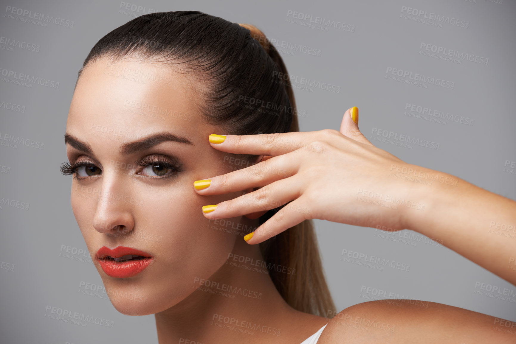 Buy stock photo Woman face, beauty and hand with manicure, makeup and yellow nail polish, skin and cosmetics on grey background. Orange lipstick, color nails and model in portrait, confidence in studio and glamour