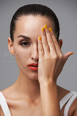 Buy stock photo Studio portrait of an attractive model covering her eyes with her hands