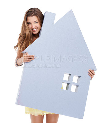 Buy stock photo Studio shot of a confident young woman holding a prop of a house in her hands