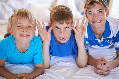 Buy stock photo Silly, funny and boy children on bed bonding for joke with comic, goofy and comedy faces. Happy, excited and portrait of young kids with crazy and playful facial expression in bedroom at modern home.