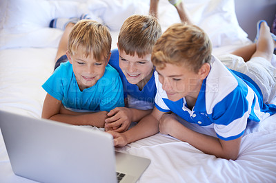 Buy stock photo Children, siblings and boys on a bed with laptop for streaming, movie or video at home bonding. Family, watching and kids in a bedroom with pc, internet or search for social media, gaming or cartoon