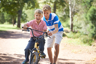 Buy stock photo Young boys riding bikes outside