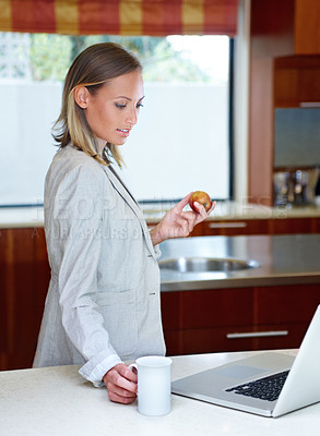 Buy stock photo Woman, coffee and apple by laptop in kitchen for morning, healthy breakfast or diet at home. Female person or freelancer with cup of tea and organic fruit by computer for business, meal or nutrition
