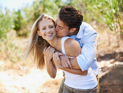 Buy stock photo Couple, face and happy with kiss in nature or relationship for holiday, vacation or travel. Romance, man and woman with smile outdoor in forest with embrace for bonding, love or relax in woods