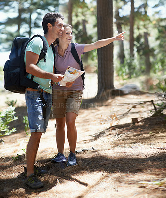 Buy stock photo Couple, trekking in nature and map for direction, documents guide or location information of forest travel or journey. Man and woman hiking with infographics, search woods and pointing to destination