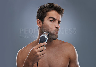 Buy stock photo Man, shaving and machine in studio for beard grooming, skincare and portrait by grey background. Person, model and self care for hygiene, facial hair removal and electric razor for cosmetic change
