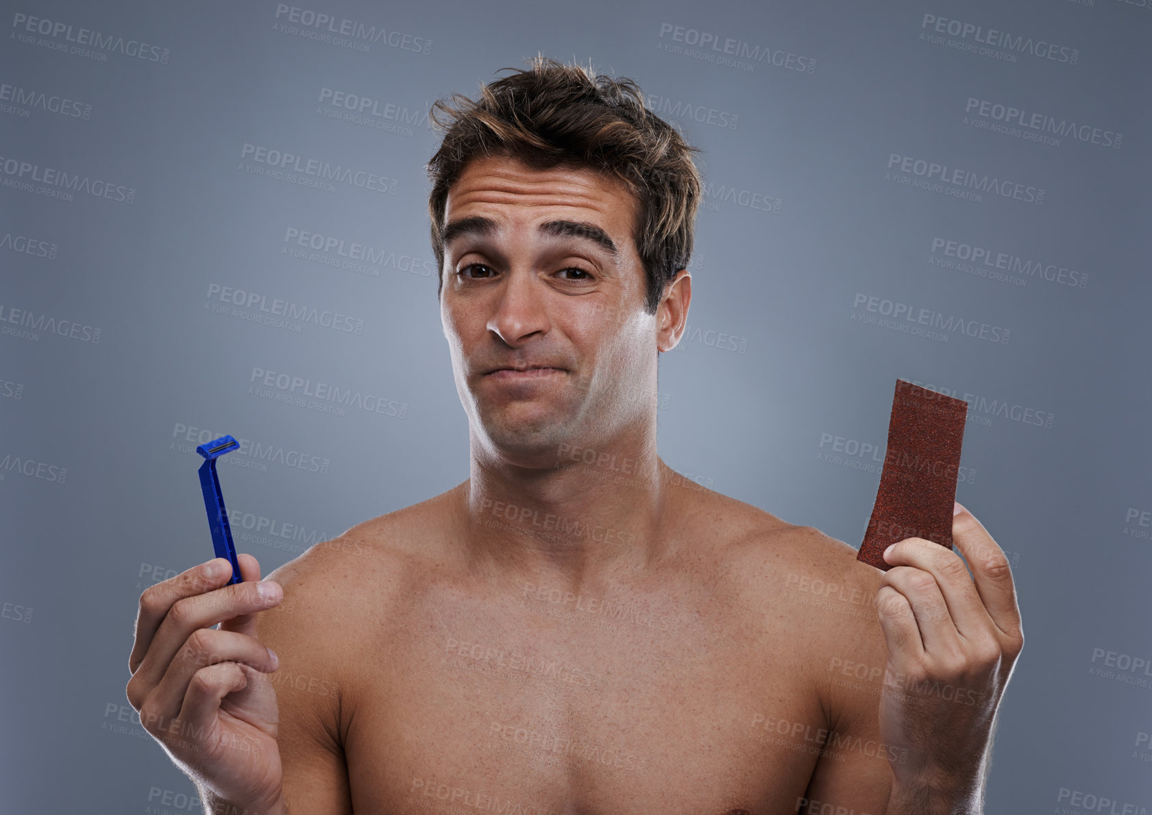 Buy stock photo Man, hair removal and choice with doubt, razor and beauty with decision and studio background with options and products. Face, wellness or model shaving for skincare, routine treatment and sand paper