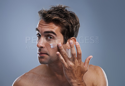 Buy stock photo Portrait, cream and man with skincare, cosmetics and beauty on a grey studio background. Portrait, person and model with grooming routine and treatment with lotion and moisture with wellness and glow