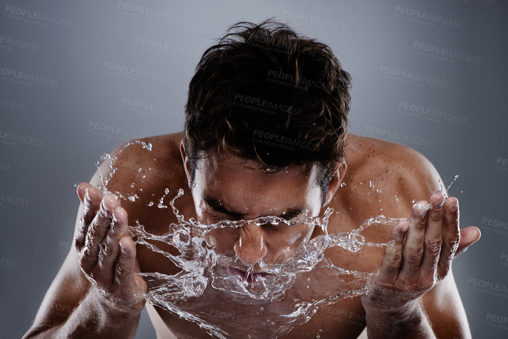 Buy stock photo Water, splash and man wash face for bathroom routine, morning facial cleanse or skincare. Studio, wellness and wet model with hygiene treatment, grooming and skin cleaning on grey background