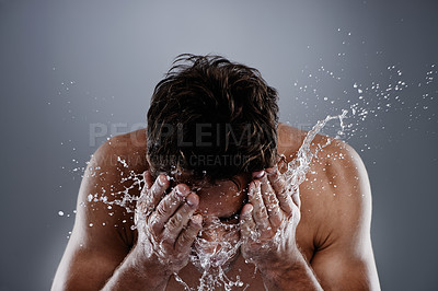 Buy stock photo Studio shot of a man washing his face