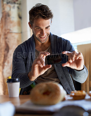 Buy stock photo Shot of a young man in a cafe taking a picture of his food