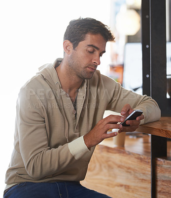 Buy stock photo Phone, networking and young man in a cafe on social media, mobile app or the internet at table. Technology, reading and male person scroll on website with cellphone in restaurant or coffee shop.